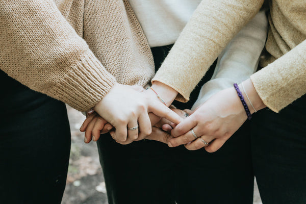 the-arms-of-people-in-sweaters-holding-hands